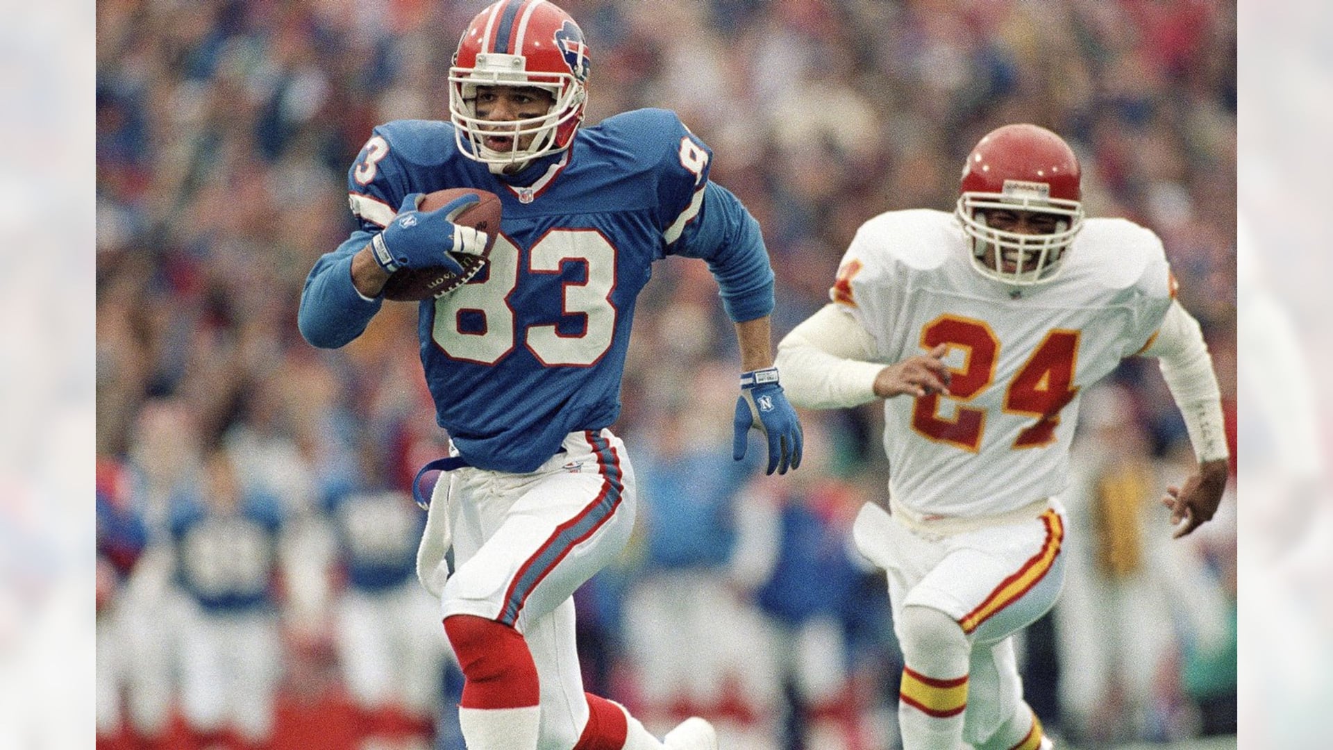 Andre Reed running with the ball in his Buffalo Bills #83 jersey during a playoff game