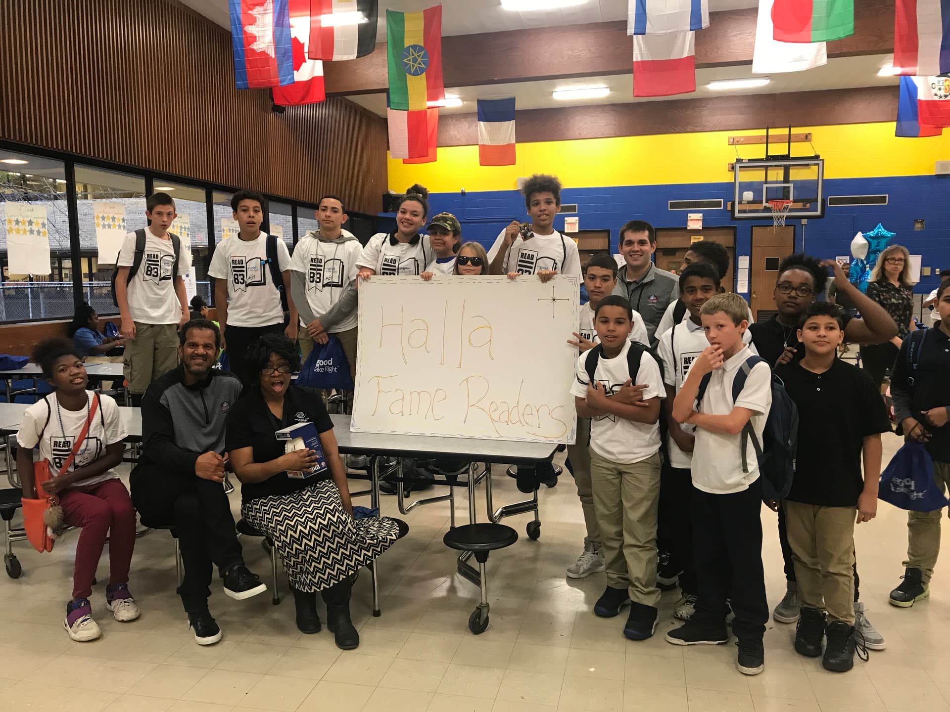 Andre Reed with kids holding "Halla Fame Readers" signs at a school event