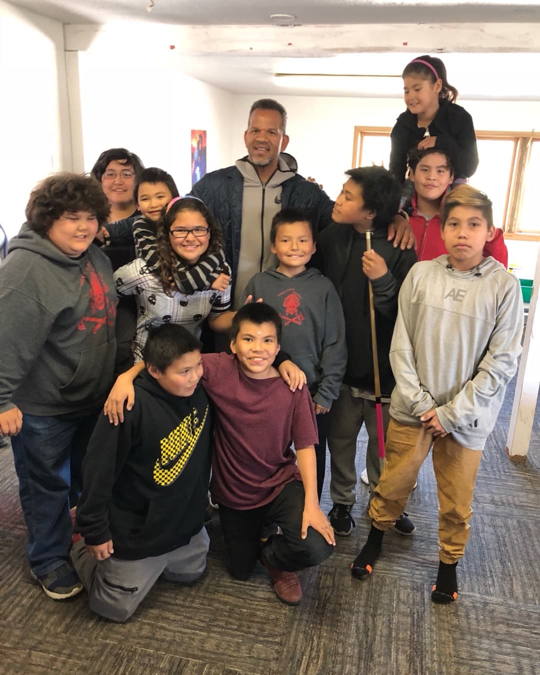 Andre Reed surrounded by a group of youth during a community center visit