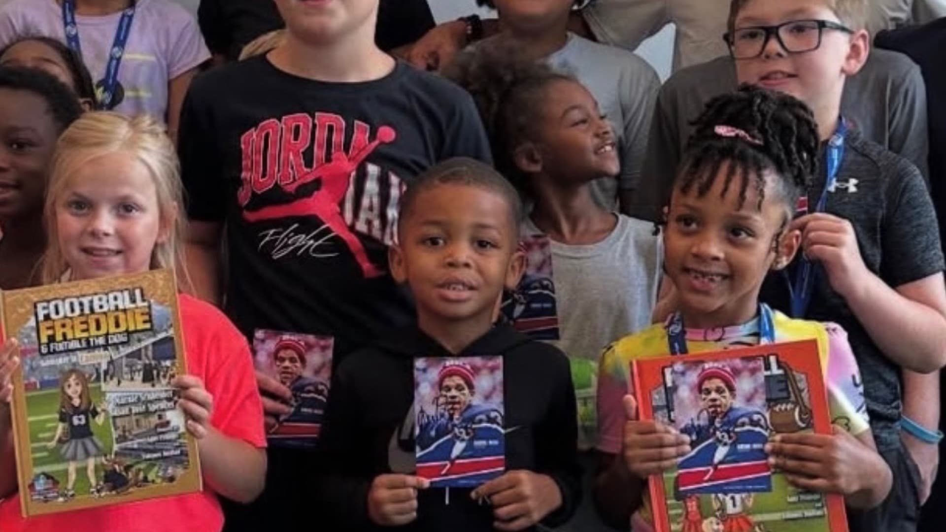 A room full of kids holding their reading magazines at a Read with Reed event