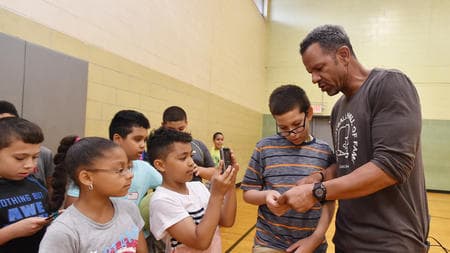 Andre Reed mentoring kids at a Boys & Girls Club gymnasium