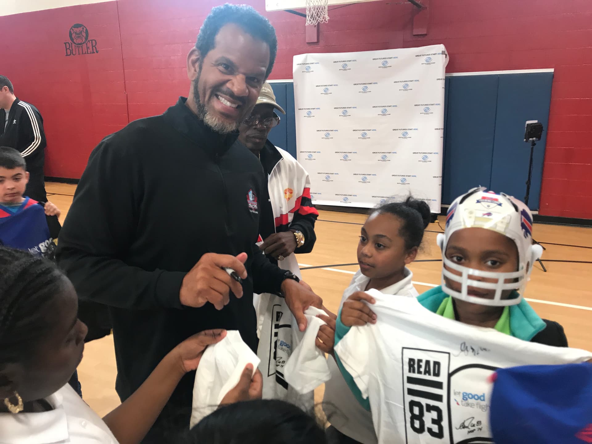 Andre Reed signing Read 83 gear for kids in a school gym