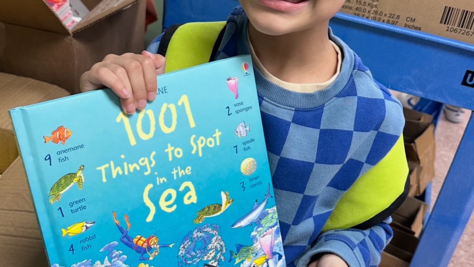 A boy holding a book he picked out